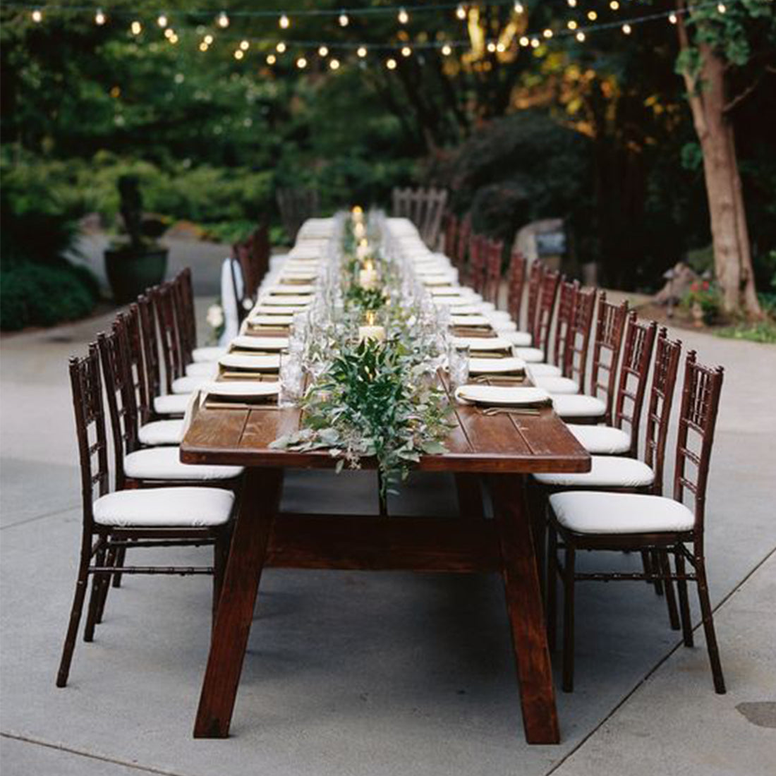 One long table and chairs with greenery and candles with a link to a blog post on How to style a minimalist wedding